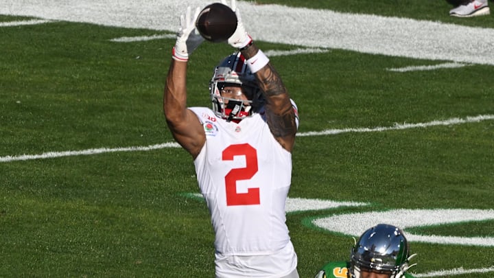 Jan 1, 2025; Pasadena, CA, USA; Ohio State Buckeyes wide receiver Emeka Egbuka (2) makes a leaping catch in front of Oregon Ducks defensive back Nikko Reed (9) during range first quarter at Rose Bowl Stadium. Mandatory Credit: Robert Hanashiro-Imagn Images Jan 1, 2025; Pasadena, CA, USA; Ohio State Buckeyes wide receiver Emeka Egbuka (2) makes a leaping catch in front of Oregon Ducks defensive back Nikko Reed (9) during range first quarter at Rose Bowl Stadium. Mandatory Credit: Robert Hanashiro-Imagn Images