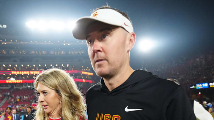 Nov 29, 2025; Los Angeles, California, USA; Southern California Trojans head coach Lincoln Riley walks with wife Caitlin Riley after the game against the UCLA Bruins at United Airlines Field at Los Angeles Memorial Coliseum. Mandatory Credit: Kirby Lee-Imagn Images