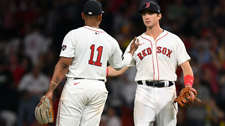 Boston Red Sox third baseman Rafael Devers (11) high-fives former first baseman Bobby Dalbec (29) after a game against the Philadelphia Phillies at Fenway Park.