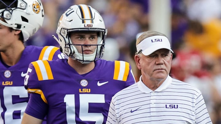 Sep 24, 2022; Baton Rouge, Louisiana, USA; LSU Tigers head coach Brian Kelly looks on with quarterback Garrett Nussmeier (13) and quarterback George Hamsley (16) and safety Sage Ryan (15) during warmups before the game against the New Mexico Lobos at Tiger Stadium. Mandatory Credit: Stephen Lew-Imagn Images Sep 24, 2022; Baton Rouge, Louisiana, USA; LSU Tigers head coach Brian Kelly looks on with quarterback Garrett Nussmeier (13) and quarterback George Hamsley (16) and safety Sage Ryan (15) during warmups before the game against the New Mexico Lobos at Tiger Stadium. Mandatory Credit: Stephen Lew-Imagn Images
