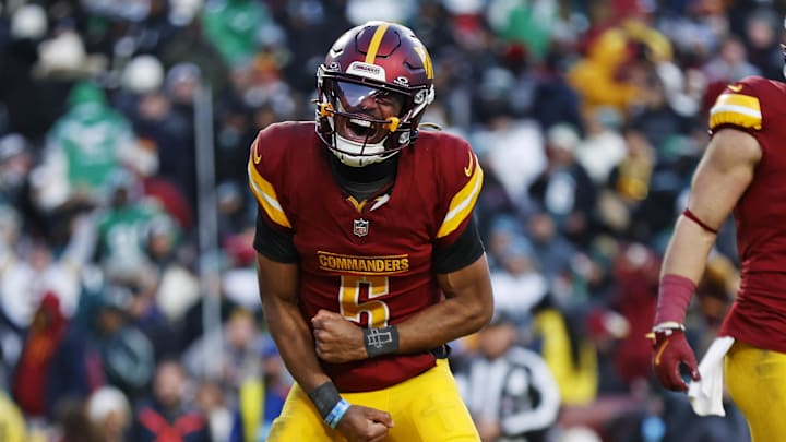 Dec 22, 2024; Landover, Maryland, USA; Washington Commanders quarterback Jayden Daniels (5) celebrates after throwing the game winning touchdown during the fourth quarter against the Philadelphia Eagles at Northwest Stadium. Mandatory Credit: Peter Casey-Imagn Images