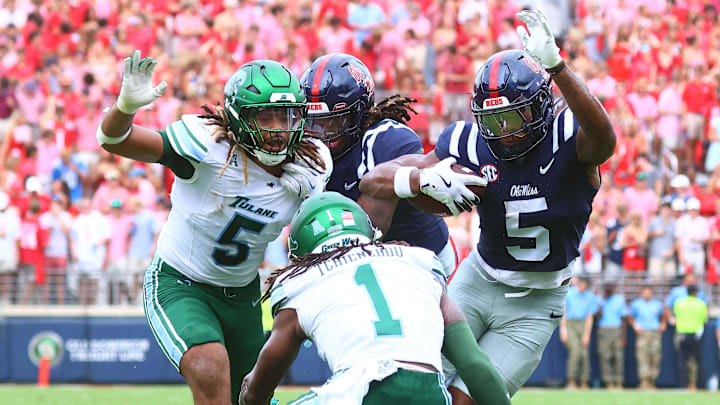 Sep 20, 2025; Oxford, Mississippi, USA; Mississippi Rebels running back Kewan Lacy (5) runs the ball as Tulane Green Wave defensive end Harvey Dyson (5) and Tulane Green Wave defensive back Jack Tchienchou (1) attempt to make the tackle during the first quarter at Vaught-Hemingway Stadium. Mandatory Credit: Petre Thomas-Imagn Images