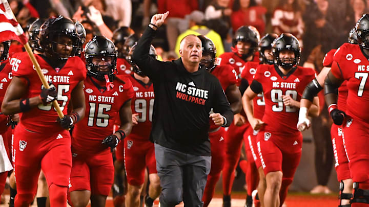Nov 4, 2023; Raleigh, North Carolina, USA; North Carolina State Wolfpack head coach Dave Doeren (center) lead his team onto the field prior to a game against the Miami Hurricanes at Carter-Finley Stadium. Mandatory Credit: Rob Kinnan-Imagn Images