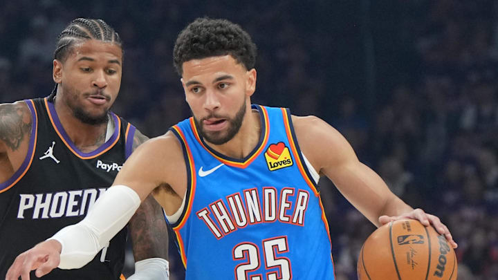 Apr 25, 2026; Phoenix, Arizona, USA; Oklahoma City Thunder guard Ajay Mitchell (25) drives past Phoenix Suns guard Jalen Green (4) in the first half during game three of the first round of the 2026 NBA Playoffs at Mortgage Matchup Center. Mandatory Credit: Rick Scuteri-Imagn Images