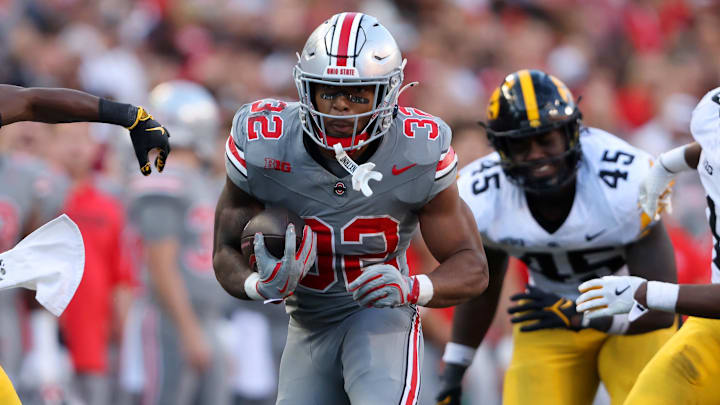 Oct 5, 2024; Columbus, Ohio, USA; Ohio State Buckeyes running back TreVeyon Henderson (32) runs the ball against Iowa Hawkeyes linebacker Nick Jackson (10) and defensive back Jermari Harris (27) during the fourth quarter at Ohio Stadium. Mandatory Credit: Joseph Maiorana-Imagn Images