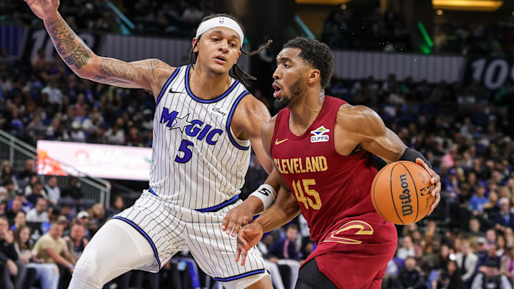 Jan 24, 2026; Orlando, Florida, USA; Cleveland Cavaliers guard Donovan Mitchell (45) drives around Orlando Magic forward Paolo Banchero (5) during the second half at Kia Center. Mandatory Credit: Mike Watters-Imagn Images