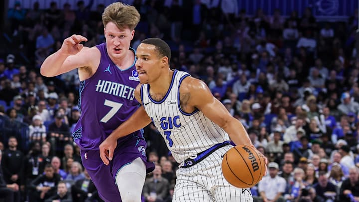 Dec 26, 2025; Orlando, Florida, USA; Orlando Magic forward Paolo Banchero (5) drives around Charlotte Hornets guard Kon Knueppel (7) during the first quarter at Kia Center. Mandatory Credit: Mike Watters-Imagn Images
