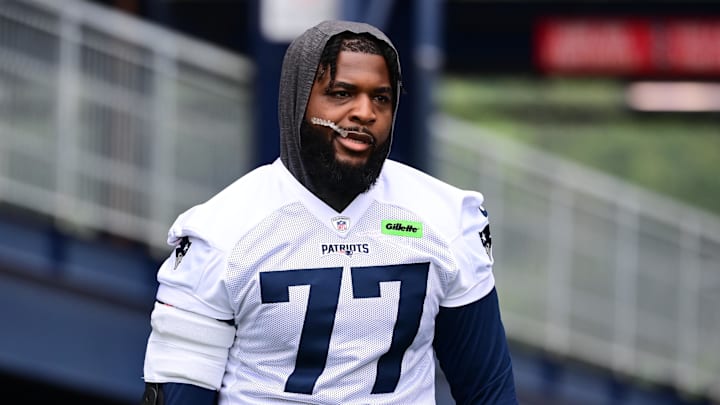 Jul 24, 2024; Foxborough, MA, USA; New England Patriots offensive tackle Chukwuma Okorafor (77) walks to the practice field during training camp at Gillette Stadium. Mandatory Credit: Eric Canha-Imagn Images