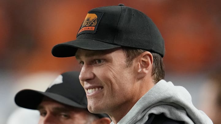 Jan 19, 2026; Miami Gardens, FL, USA; Tom Brady looks on from the sideline before the CFP National Championship college football game between the Indiana Hoosiers and the Miami Hurricanes at Hard Rock Stadium. Mandatory Credit: Kirby Lee-Imagn Images Jan 19, 2026; Miami Gardens, FL, USA; Tom Brady looks on from the sideline before the CFP National Championship college football game between the Indiana Hoosiers and the Miami Hurricanes at Hard Rock Stadium. Mandatory Credit: Kirby Lee-Imagn Images