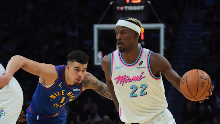 Jan 17, 2025; Miami, Florida, USA; Miami Heat forward Jimmy Butler (22) drives to the basket past Denver Nuggets forward Michael Porter Jr. (1) during the third quarter at Kaseya Center. Mandatory Credit: Sam Navarro-Imagn Images