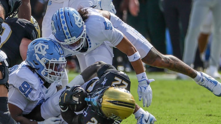 Sep 20, 2025; Orlando, Florida, USA; UCF Knights running back Myles Montgomery (22) is tackled by North Carolina Tar Heels defensive lineman Leroy Jackson (91) during the first quarter at the Bounce House Stadium. Mandatory Credit: Mike Watters-Imagn Images