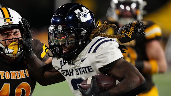Oct 26, 2024; Laramie, Wyoming, USA; Utah State Aggies running back Rahsul Faison (3) runs against the Wyoming Cowboys during the second quarter at Jonah Field at War Memorial Stadium. Mandatory Credit: Troy Babbitt-Imagn Images Oct 26, 2024; Laramie, Wyoming, USA; Utah State Aggies running back Rahsul Faison (3) runs against the Wyoming Cowboys during the second quarter at Jonah Field at War Memorial Stadium. Mandatory Credit: Troy Babbitt-Imagn Images