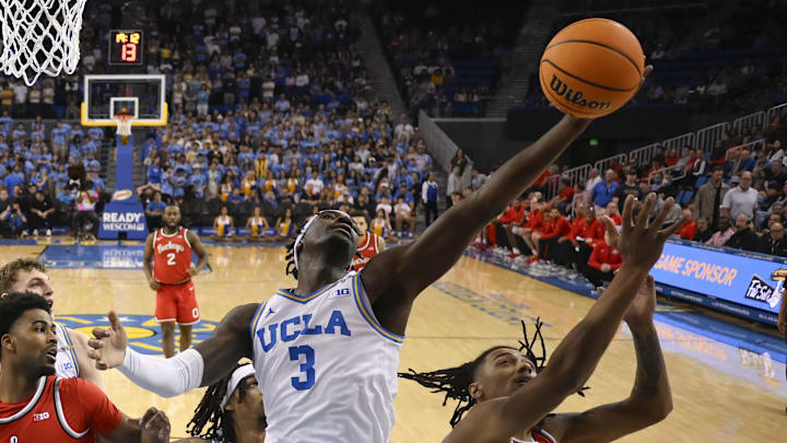 Feb 23, 2025; Los Angeles, California, USA; UCLA Bruins guard Eric Dailey Jr. (3) grabs a rebound over Ohio State Buckeyes forward Devin Royal (21) during the first half at Pauley Pavilion presented by Wescom. Mandatory Credit: Robert Hanashiro-Imagn Images
