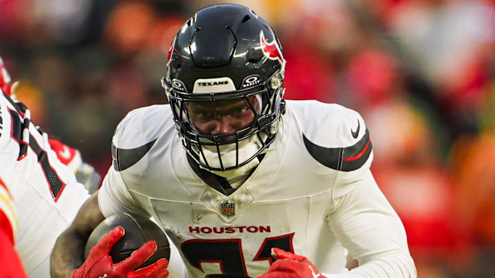 Jan 18, 2025; Kansas City, Missouri, USA; Houston Texans running back Dameon Pierce (31) runs the ball against Kansas City Chiefs safety Jaden Hicks (21) during the second half in a 2025 AFC divisional round game at GEHA Field at Arrowhead Stadium. Mandatory Credit: Jay Biggerstaff-Imagn Images