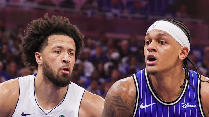 Orlando Magic forward Paolo Banchero looks to pass in front of Detroit Pistons guard Cade Cunningham.