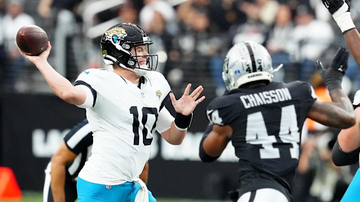 Dec 22, 2024; Paradise, Nevada, USA; Jacksonville Jaguars quarterback Mac Jones (10) is pressured by Las Vegas Raiders defensive end K'Lavon Chaisson (44) during the first quarter at Allegiant Stadium. Mandatory Credit: Stephen R. Sylvanie-Imagn Images