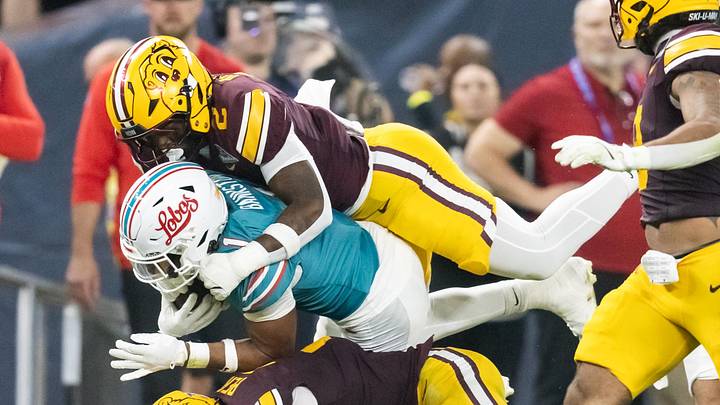 Dec 26, 2025; Phoenix, AZ, USA; New Mexico Lobos running back Damon Bankston (1) is tackled by Minnesota Gophers linebacker Emmanuel Karmo (2) and defensive back Koi Perich (3) during the first half of the Rate Bowl at Chase Field. Mandatory Credit: Mark J. Rebilas-Imagn Images Dec 26, 2025; Phoenix, AZ, USA; New Mexico Lobos running back Damon Bankston (1) is tackled by Minnesota Gophers linebacker Emmanuel Karmo (2) and defensive back Koi Perich (3) during the first half of the Rate Bowl at Chase Field. Mandatory Credit: Mark J. Rebilas-Imagn Images