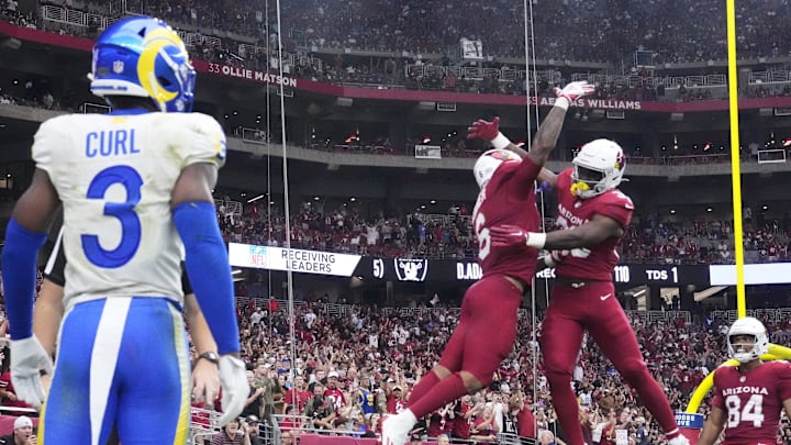 Arizona Cardinals running back James Conner (6) celebrates his touchdown run with running back Trey Benson (33) during the third quarter against the Los Angeles Rams at State Farm Stadium.