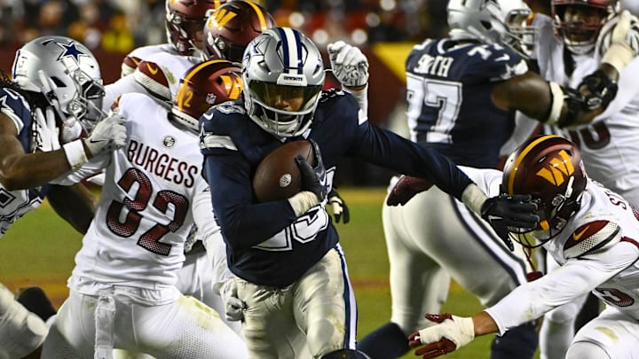 Jan 7, 2024; Landover, Maryland, USA; Dallas Cowboys running back Rico Dowdle (23) carries the ball past Washington Commanders safety Terrell Burgess (32) during the second half at FedExField. Mandatory Credit: Brad Mills-Imagn Images