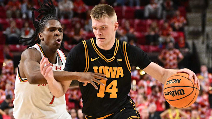 Feb 11, 2026; College Park, Maryland, USA;  Iowa Hawkeyes guard Bennett Stirtz (#14) controls the ball while being defended by Maryland Terrapins guard Andre Mills (7) in the first half at Xfinity Center. Mandatory Credit: Jamie Sabau-Imagn Images
