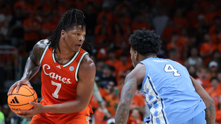 Feb 10, 2026; Coral Gables, Florida, USA; Miami Hurricanes forward Shelton Henderson (7) protects the basketball against North Carolina Tar Heels guard Jaydon Young (4) during the first half at Watsco Center. Mandatory Credit: Sam Navarro-Imagn Images
