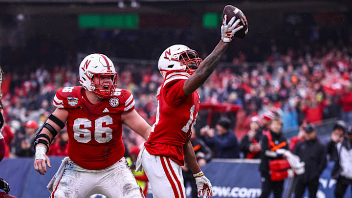 Nebraska running back Rahmir Johnson holds the ball high after scoring in the 2024 Pinstripe Bowl. He is returning for the 2025 season.