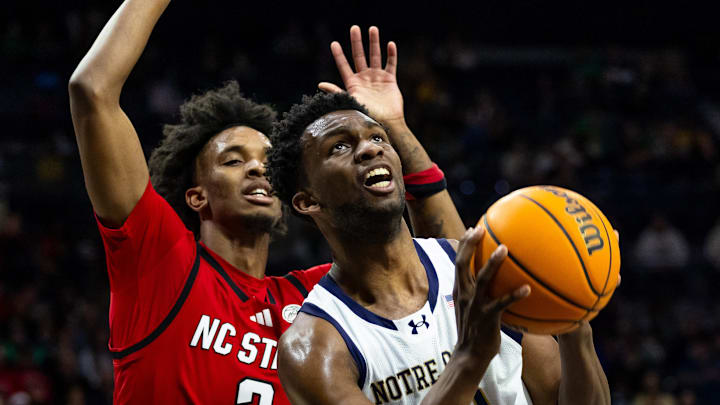 Feb 28, 2026; South Bend, Indiana, USA; Notre Dame Fighting Irish guard Sir Mohammed (13) drives past NC State Wolfpack guard Paul McNeil Jr. (2) during the first half at Purcell Pavilion at the Joyce Center. Mandatory Credit: Michael Caterina-Imagn Images