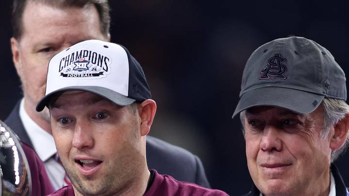 Dec 7, 2024; Arlington, TX, USA; Arizona State Sun Devils head coach Kenny Dillingham looks at the trophy after winning the Big 12 Championship game against the Iowa State Cyclones at AT&T Stadium. Mandatory Credit: Tim Heitman-Imagn Images