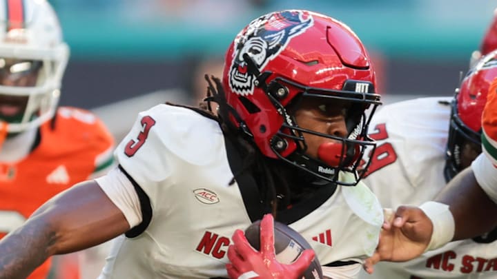 Nov 15, 2025; Miami Gardens, Florida, USA; NC State Wolfpack running back Hollywood Smothers (3) carries the football against Miami Hurricanes defensive lineman Justin Scott (5) during the second quarter at Hard Rock Stadium. Mandatory Credit: Sam Navarro-Imagn Images