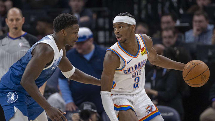 Jan 20, 2024; Minneapolis, Minnesota, USA; Oklahoma City Thunder guard Shai Gilgeous-Alexander (2) looks to pass the ball as Minnesota Timberwolves guard Anthony Edwards (5) plays defense in the second half at Target Center. Mandatory Credit: Jesse Johnson-Imagn Images