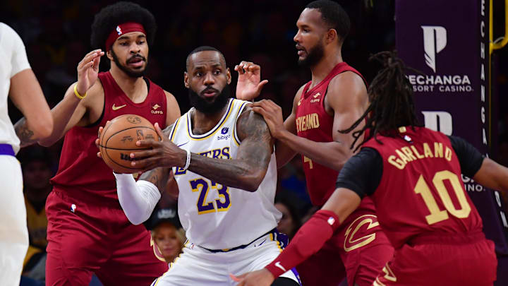 Apr 6, 2024; Los Angeles, California, USA;  Los Angeles Lakers forward LeBron James (23) controls the ball against Cleveland Cavaliers center Jarrett Allen (31) forward Evan Mobley (4) and guard Darius Garland (10) during the first half at Crypto.com Arena. Mandatory Credit: Gary A. Vasquez-Imagn Images