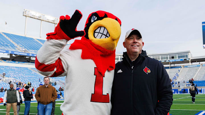 Nov 30, 2024; Lexington, Kentucky, USA; Louisville Cardinals head coach Jeff Brohm poses for a photo with the Cardinal mascot after the game against the Kentucky Wildcats at Kroger Field.