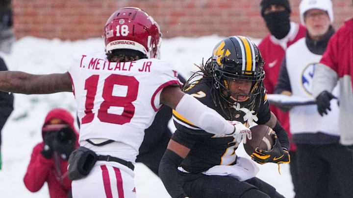Missouri Tigers wide receiver Marquis Johnson (2) runs the ball as Arkansas Razorbacks defensive back TJ Metcalf (18) attempts the tackle during the first half at Faurot Field at Memorial Stadium. 