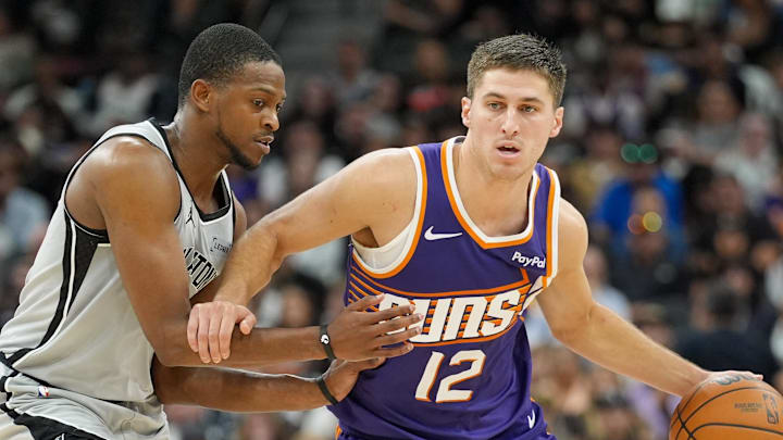 Mar 19, 2026; San Antonio, Texas, USA;  Phoenix Suns guard Collin Gillespie (12) dribbles against San Antonio Spurs guard De'aaron Fox (4) in the second half at Frost Bank Center. Mandatory Credit: Daniel Dunn-Imagn Images