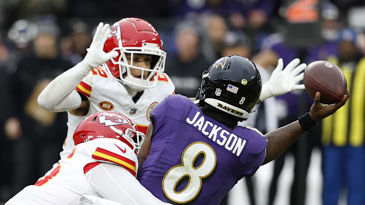 Jan 28, 2024; Baltimore, Maryland, USA; Baltimore Ravens quarterback Lamar Jackson (8) throws the ball around Kansas City Chiefs cornerback Trent McDuffie (22) while being sacked by Chiefs defensive tackle Chris Jones (95) during the first half in the AFC Championship football game at M&T Bank Stadium. Mandatory Credit: Geoff Burke-Imagn Images