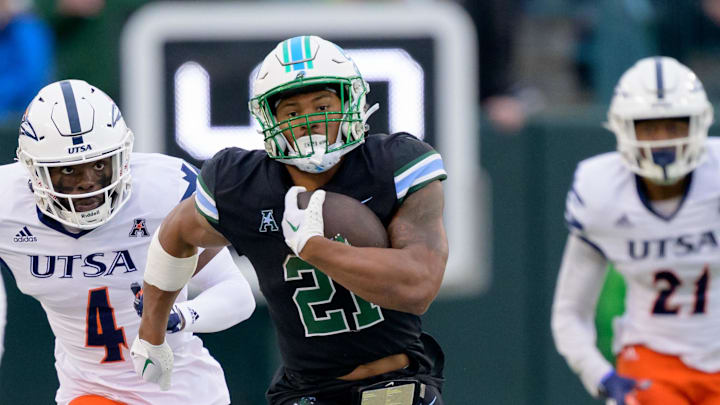 Nov 24, 2023; New Orleans, Louisiana, USA; Tulane Green Wave running back Makhi Hughes (21) runs against UTSA Roadrunners running back Kevorian Barnes (4) during the first half at Yulman Stadium. Mandatory Credit: Matthew Hinton-Imagn Images