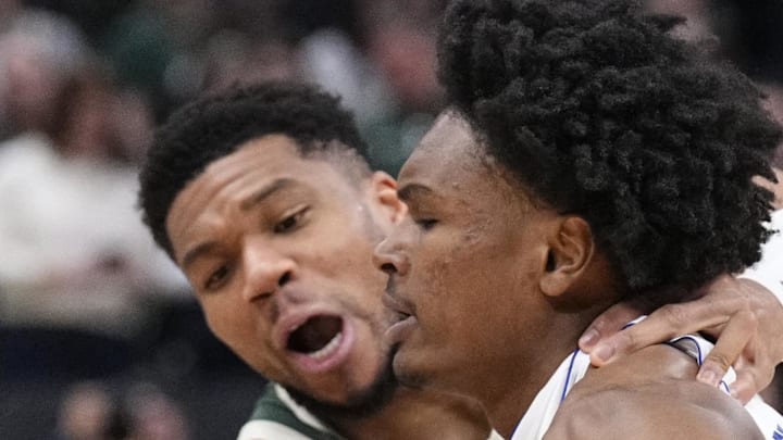 Milwaukee Bucks forward Giannis Antetokounmpo battles for possession of the ball with Detroit Pistons guard Ausar Thompson.
