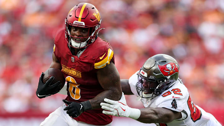 Sep 8, 2024; Tampa, Florida, USA; Washington Commanders running back Brian Robinson Jr. (8) breaks a tackle from Tampa Bay Buccaneers linebacker K.J. Britt (52) in the third quarter at Raymond James Stadium. Mandatory Credit: Nathan Ray Seebeck-Imagn Images