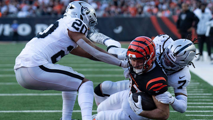Las Vegas Raiders safety Tre’von Moehrig (7) and Las Vegas Raiders safety Isaiah Pola-Mao (20) tackle Cincinnati Bengals tight end Tanner Hudson (87) at the 1-yard-line in the fourth quarter of the NFL game at Paycor Stadium in Cincinnati on Sunday, Nov. 3, 2024.