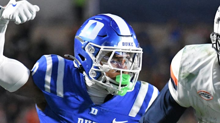 Nov 15, 2025; Durham, North Carolina, USA;  Duke Blue Devils cornerback Chandler Rivers (0) attempts to swat the ball from Virginia Cavaliers wide receiver Trell Harris (11) during the third quarter at Wallace Wade Stadium. Mandatory Credit: Zachary Taft-Imagn Images