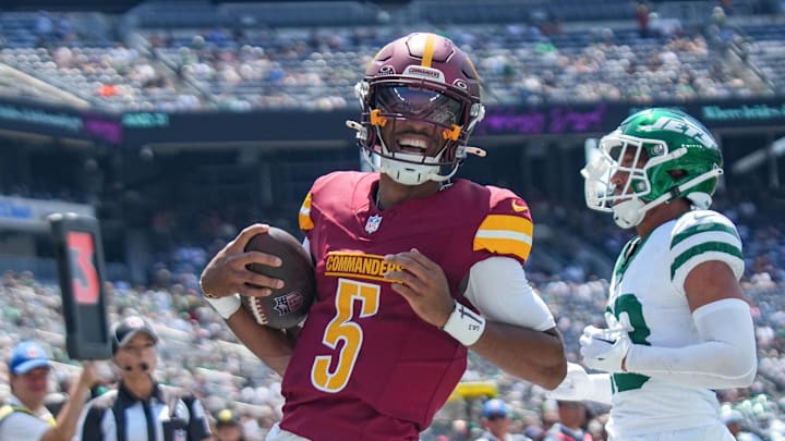 Aug 10, 2024; East Rutherford, New Jersey, USA; Washington Commanders quarterback Jayden Daniels (5) rushes for a touchdown during the first quarter against the New York Jets at MetLife Stadium. Mandatory Credit: Lucas Boland-Imagn Images