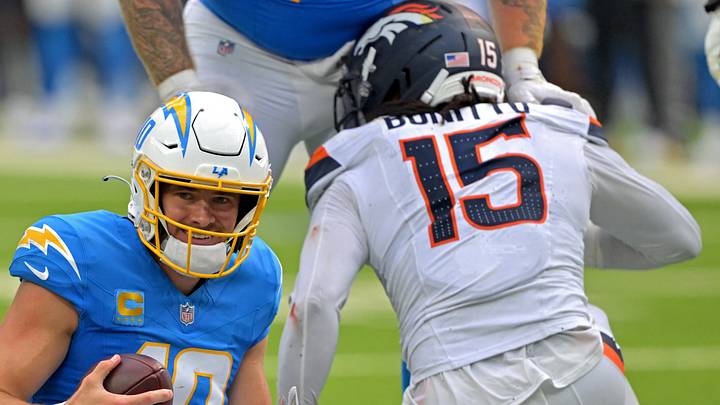 Los Angeles Chargers quarterback Justin Herbert (10) and Denver Broncos linebacker Nik Bonitto (15) Los Angeles Chargers quarterback Justin Herbert (10) and Denver Broncos linebacker Nik Bonitto (15)