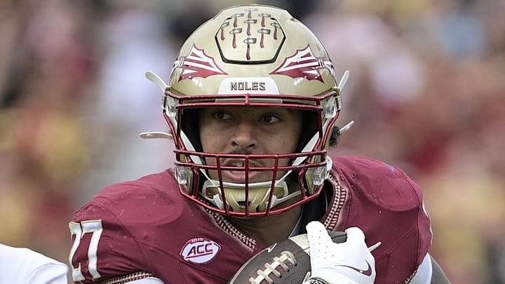 Oct 11, 2025; Tallahassee, Florida, USA; Florida State Seminoles running back Gavin Sawchuk (27) runs the ball past Pittsburgh Panthers linebacker Kyle Louis (9) during the first half at Doak S. Campbell Stadium. Mandatory Credit: Melina Myers-Imagn Images