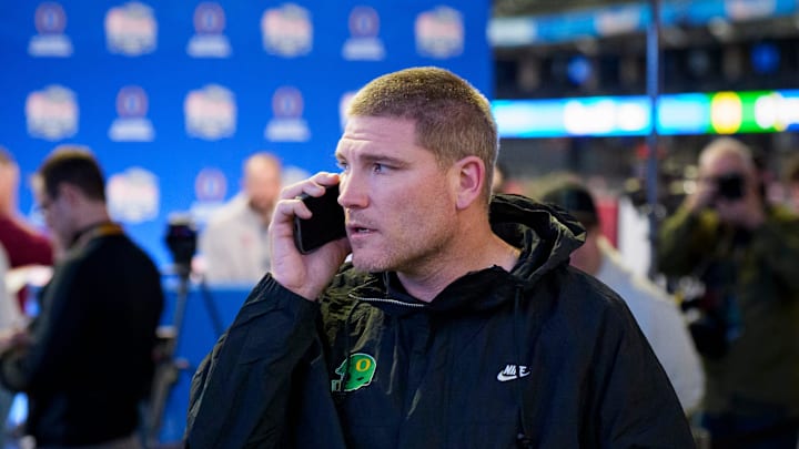 Oregon defensive coordinator Tosh Lupoi talks on the phone as Indiana speaks during a media day as the Oregon Ducks arrive on Jan. 7, 2025, in Atlanta, Georgia ahead of the Peach Bowl at Mercedes-Benz Stadium. Oregon defensive coordinator Tosh Lupoi talks on the phone as Indiana speaks during a media day as the Oregon Ducks arrive on Jan. 7, 2025, in Atlanta, Georgia ahead of the Peach Bowl at Mercedes-Benz Stadium.