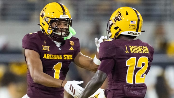 Nov 28, 2025; Tempe, Arizona, USA; Arizona State Sun Devils defensive back Javan Robinson (12) celebrates a fumble recovery with Keith Abney II (1) against the Arizona Wildcats in the first half during the 99th Territorial Cup at Mountain America Stadium. Mandatory Credit: Mark J. Rebilas-Imagn Images Nov 28, 2025; Tempe, Arizona, USA; Arizona State Sun Devils defensive back Javan Robinson (12) celebrates a fumble recovery with Keith Abney II (1) against the Arizona Wildcats in the first half during the 99th Territorial Cup at Mountain America Stadium. Mandatory Credit: Mark J. Rebilas-Imagn Images