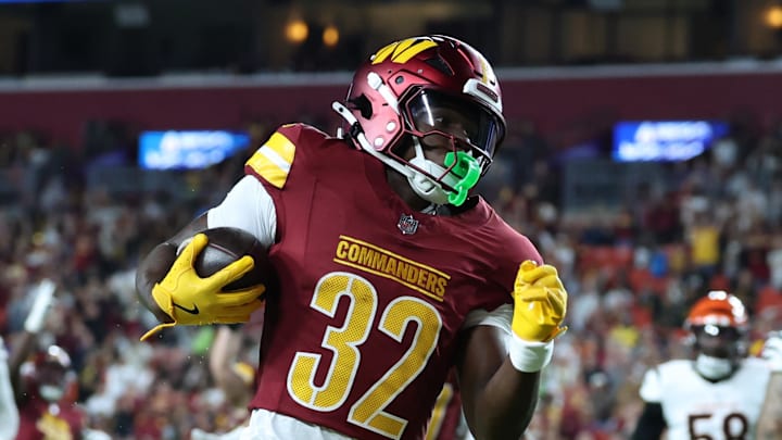 Aug 18, 2025; Landover, Maryland, USA; Washington Commanders running back Jacory Croskey-Merritt (32) scores a touchdown past Cincinnati Bengals safety Daijahn Anthony (33) during the first half at Northwest Stadium. Mandatory Credit: Amber Searls-Imagn Images