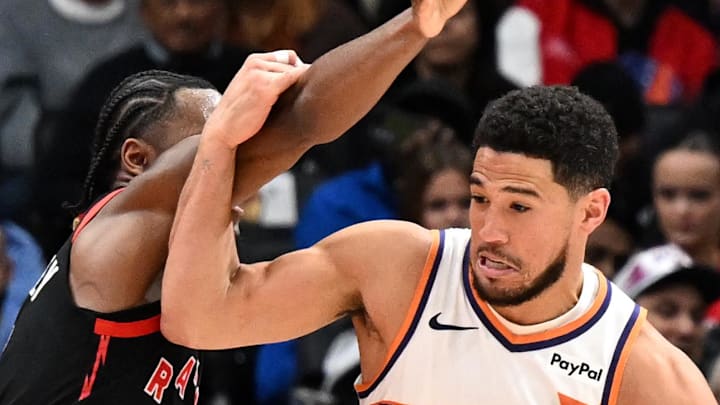 Phoenix Suns guard Devin Booker dribbles the ball past Toronto Raptors guard Immanuel Quickley. Phoenix Suns guard Devin Booker dribbles the ball past Toronto Raptors guard Immanuel Quickley.