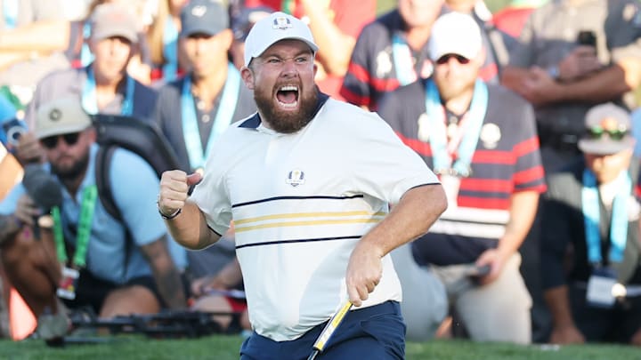 Shane Lowry birdied the 18th hole to tie his match and win the Ryder Cup for Europe.