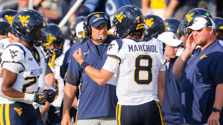 Sep 6, 2025; Athens, Ohio, USA; West Virginia Mountaineers head coach Rich Rodriguez talks with West Virginia Mountaineers quarterback Nicco Marchiol (8) during the third quarter against the Ohio Bobcats at Peden Stadium. Mandatory Credit: Ben Queen-Imagn Images