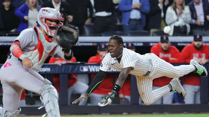 Oct 1, 2025; Bronx, New York, USA; New York Yankees second baseman Jazz Chisholm Jr. (13) slides into home to score on an hits an RBI single from New York Yankees catcher Austin Wells (28) (not pictured) during the eighth inning against the Boston Red Sox during game two of the Wildcard round for the 2025 MLB playoffs at Yankee Stadium. Mandatory Credit: Brad Penner-Imagn Images